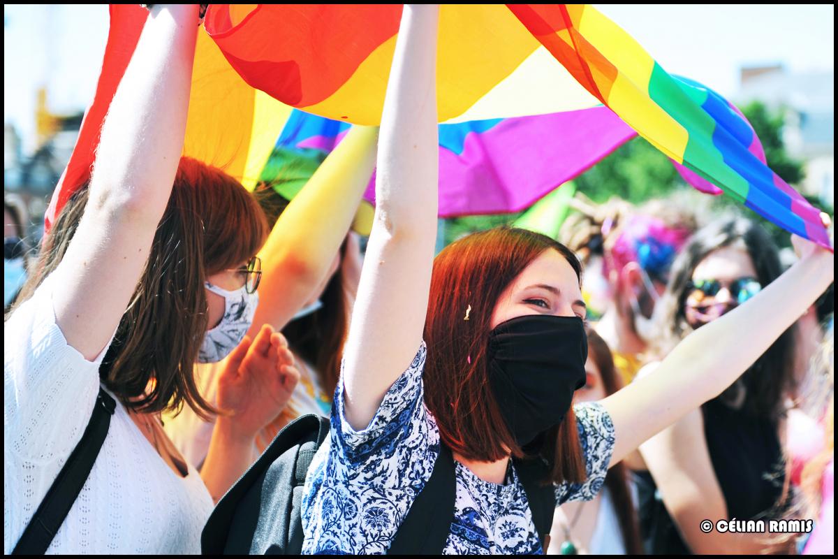 Militant-es qui portent le drapeau LGBTIQ+