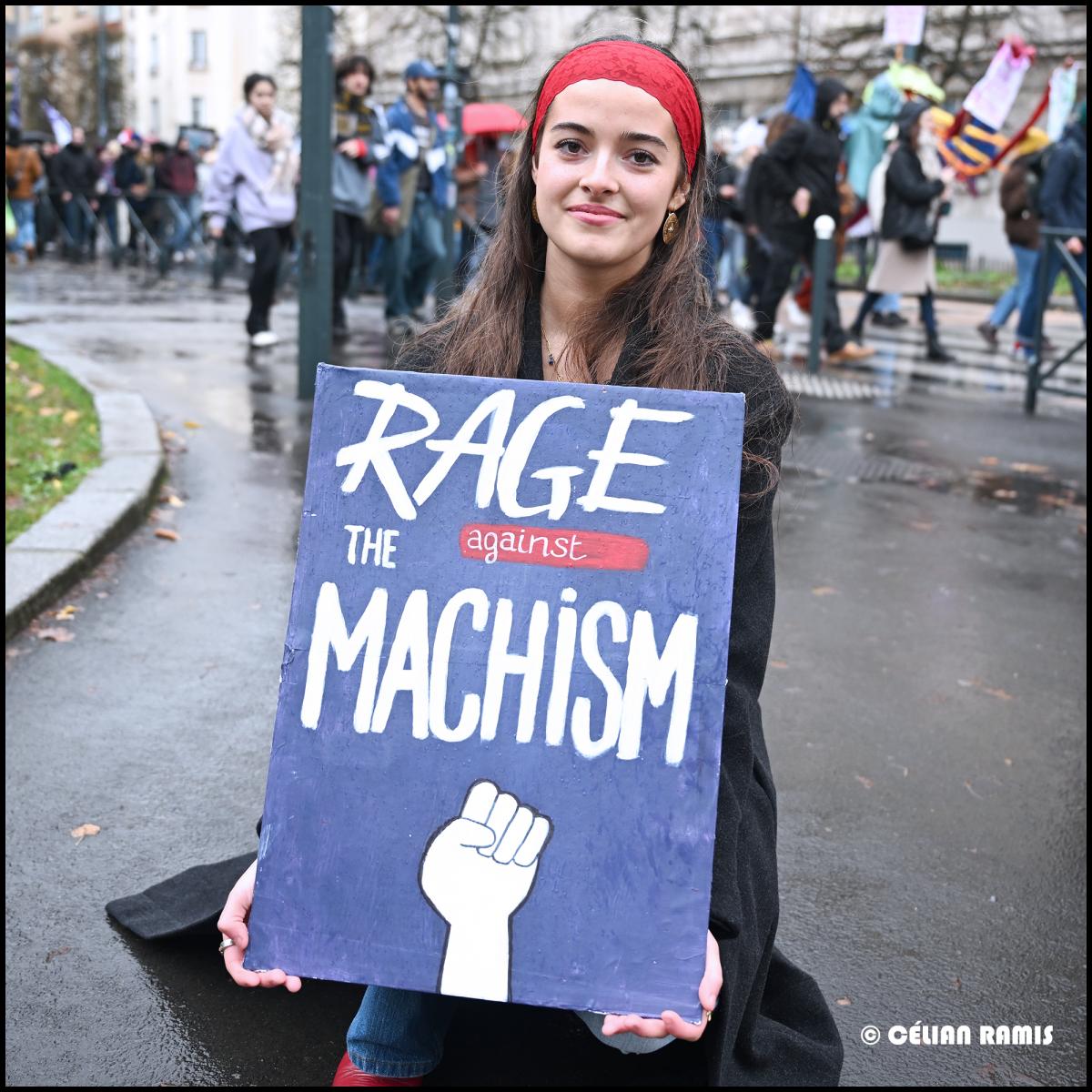 A l'occasion de la manifestation du 25 novembre, une manifestante se tient agenouillée sur l'espace public avec sa pancarte "rage against the machism"